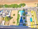 Aerial view of a beachfront property with a pool and surrounding greenery