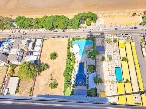 Aerial view of a beachfront property with a pool and surrounding greenery