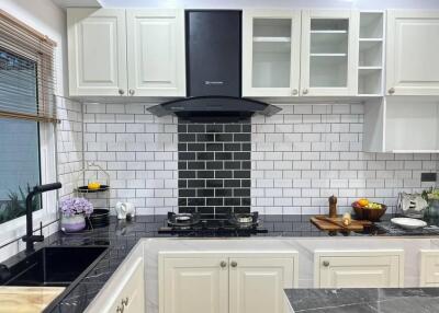 Modern kitchen with white cabinets and black countertop