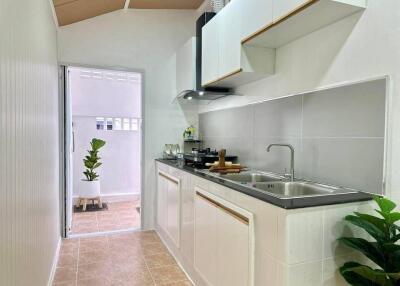 Modern compact kitchen with white cabinetry and sleek appliances