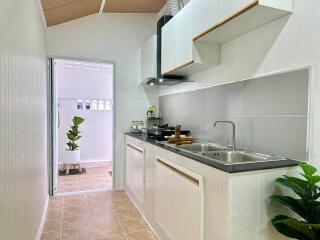 Modern compact kitchen with white cabinetry and sleek appliances