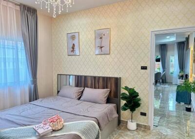 Modern bedroom with double bed, chandelier, and wall art