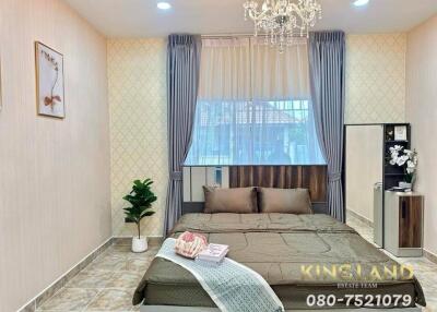 Well-furnished bedroom with a large bed, chandelier, and modern decor