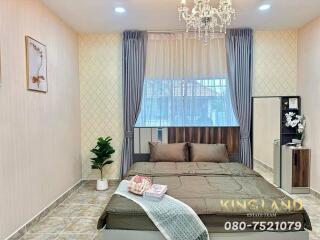 Well-furnished bedroom with a large bed, chandelier, and modern decor