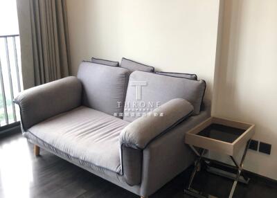 Small living area with a grey sofa and side table