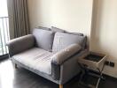 Small living area with a grey sofa and side table