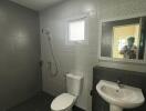 Modern bathroom with toilet, sink, and shower area