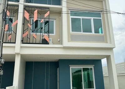 Front view of a modern townhouse with three levels and large windows