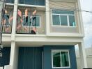 Front view of a modern townhouse with three levels and large windows