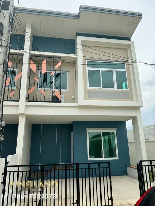 Front view of a modern townhouse with three levels and large windows