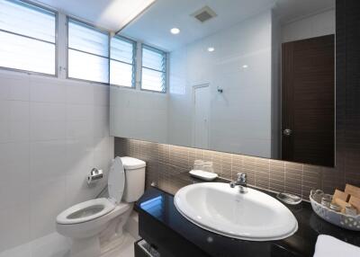 Modern bathroom with white tiles and large mirror