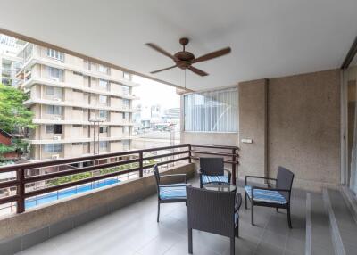 Spacious balcony with outdoor seating and ceiling fan