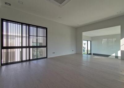 spacious empty living room with large windows and wooden flooring