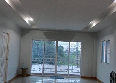 Spacious living room with large windows and a door to the balcony