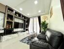 Modern living room with marble entertainment center and leather sofas