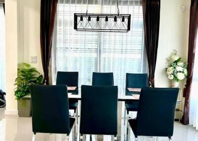 Modern dining room with sleek black chairs and elegant chandelier