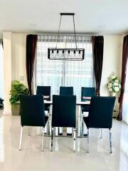 Modern dining room with sleek black chairs and elegant chandelier