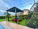 Backyard with pergola, seating area, and hanging chair next to a pool