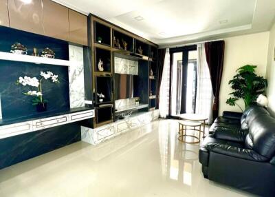 Modern living room with black leather sofas and decorative shelving