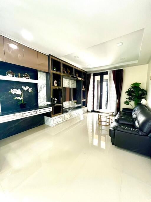 Modern living room with black leather sofas and decorative shelving