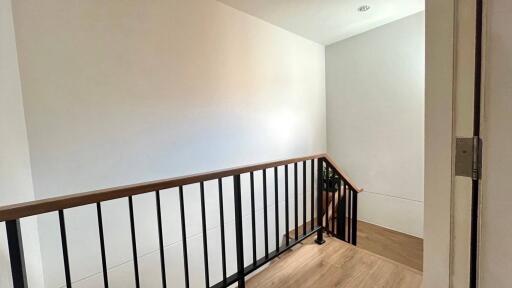 Modern staircase with wooden handrail and black metal balusters