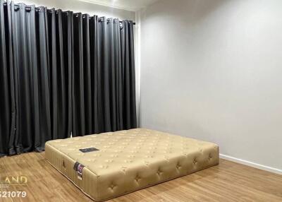 Spacious bedroom with floor mattress and dark curtains