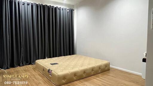 Spacious bedroom with floor mattress and dark curtains