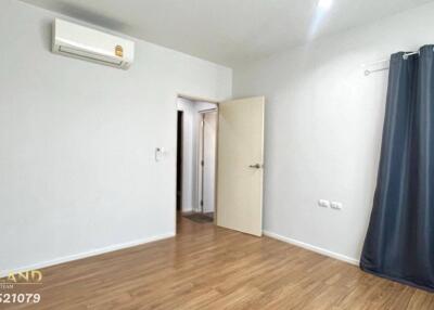 Bedroom with wooden floor, air conditioner, and open door