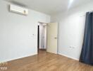 Bedroom with wooden floor, air conditioner, and open door