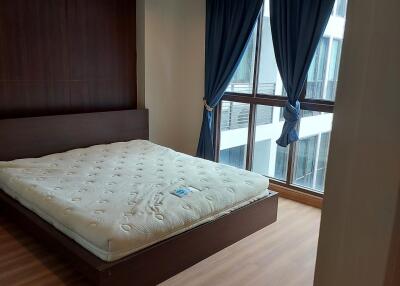 Bedroom with large windows and blue curtains