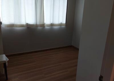 Empty bedroom with hardwood floor and curtained window