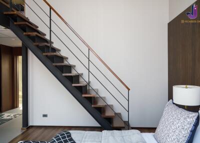 Modern bedroom with a staircase leading to an upper floor