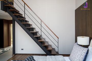 Modern bedroom with a staircase leading to an upper floor