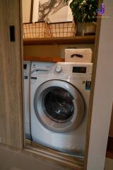 Laundry area with a washing machine and storage space