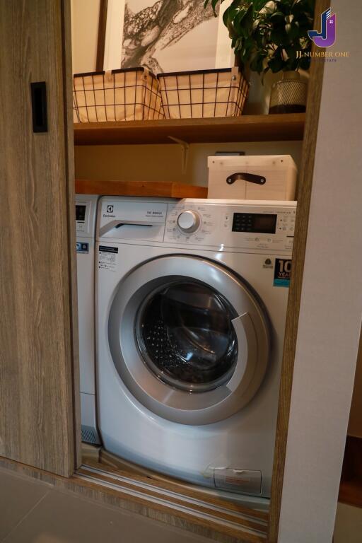 Laundry area with a washing machine and storage space