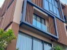 Modern multi-level building facade with large windows and balconies