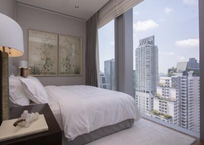 Modern bedroom with large windows overlooking cityscape