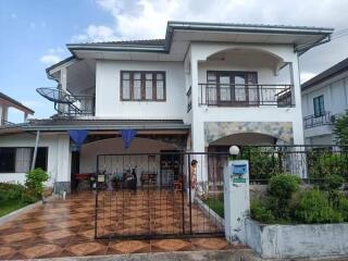 Two-story house with a tiled driveway and front yard