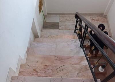 View of staircase with marble steps and metal railing