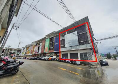 Exterior view of a commercial building with multiple floors and parking area