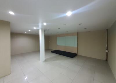 Spacious empty room with tiled floor and mirrored wall