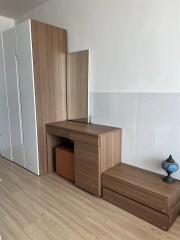 Bedroom with wooden dresser, built-in wardrobe, and decorative lamp