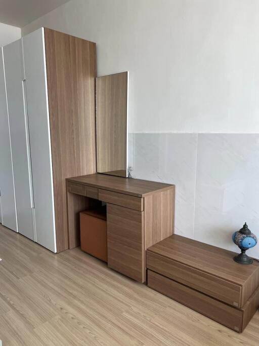 Bedroom with wooden dresser, built-in wardrobe, and decorative lamp