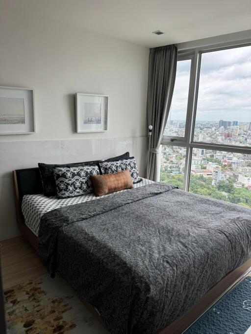 Bedroom with large windows and city view