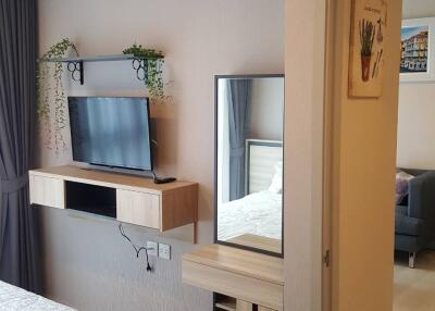 Modern bedroom with air conditioner, TV, and vanity desk