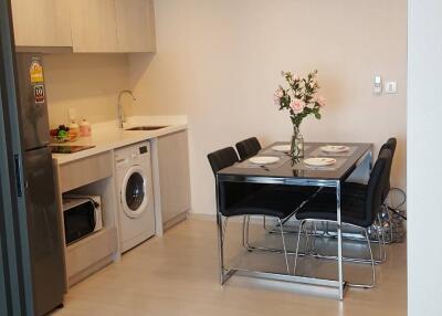 Modern kitchen with dining table, washing machine, and built-in cabinets