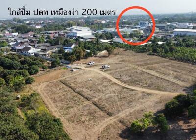 Aerial view of a plot of land for sale with nearby town infrastructure visible