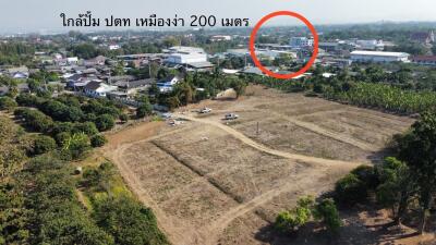 Aerial view of a plot of land for sale with nearby town infrastructure visible