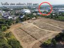 Aerial view of a plot of land for sale with nearby town infrastructure visible