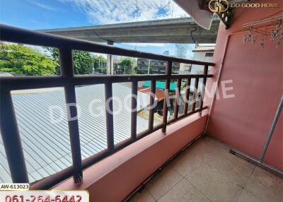 Balcony with railing overlooking adjacent buildings and greenery